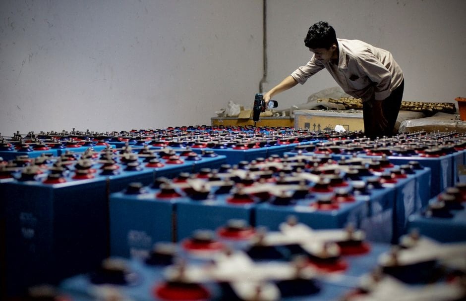 Technicien inspectant une batterie à flux redox dans un site solaire