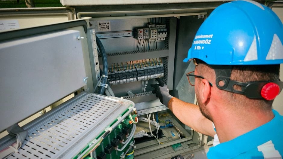 Technicien contrôlant le raccordement électrique d’une centrale photovoltaïque locale